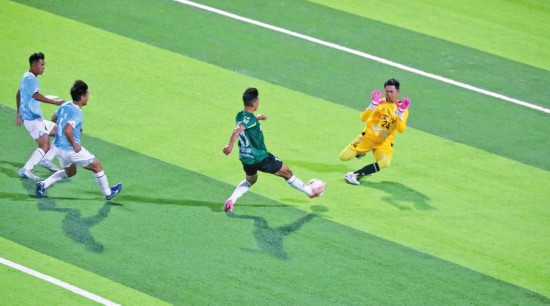 西双版纳队球员起脚射门。 本报记者 戴振华 摄